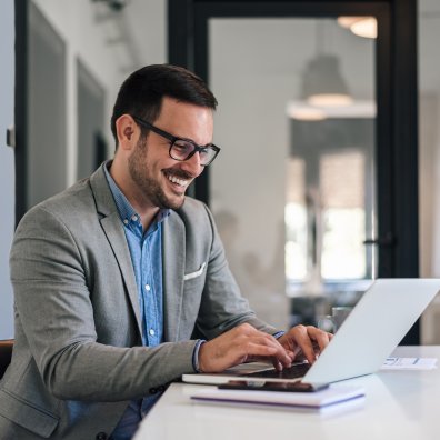 Man working on the computer and smiling. 