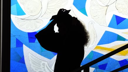Graduating woman in front of the stained glass window at ESMT Berlin