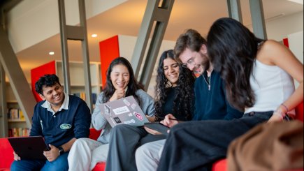 ESMT Berlin master's students laughing together in the campus library