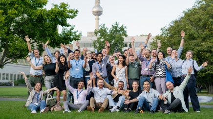 ESMT Berlin Global Online MBA students Jsmiling for the camera while in the campus garden during Berlin Experience Week