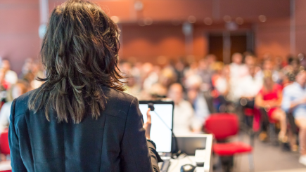 Woman speaking to audience at a conference