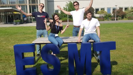 MIM students sitting on table behind ESMT letters