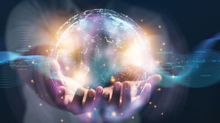 A digital world is being held by two human hands