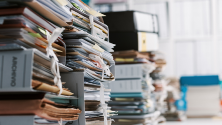 A big amount of files on an office desk are being shown.