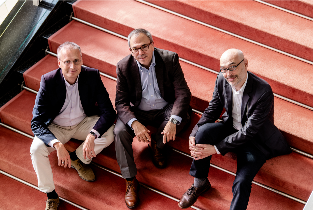 Kenneth Cukier, Viktor Mayer-Schönberger, and Francis de Véricourt sitting on stairs