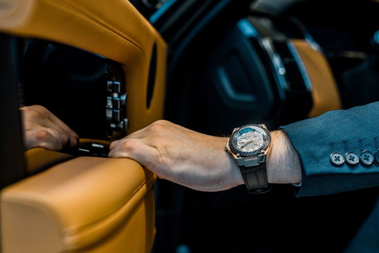 man with luxury watch opening car door 