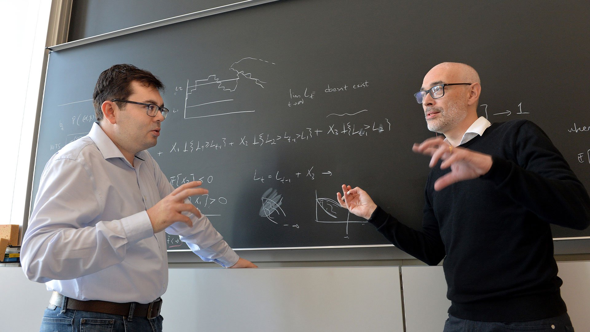 2 professors having a discussion at blackboard