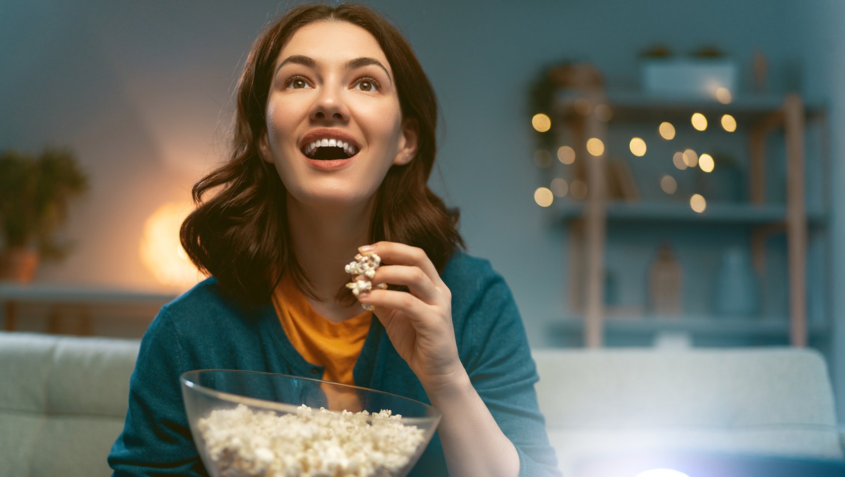 Woman watching a move and eating popcorn