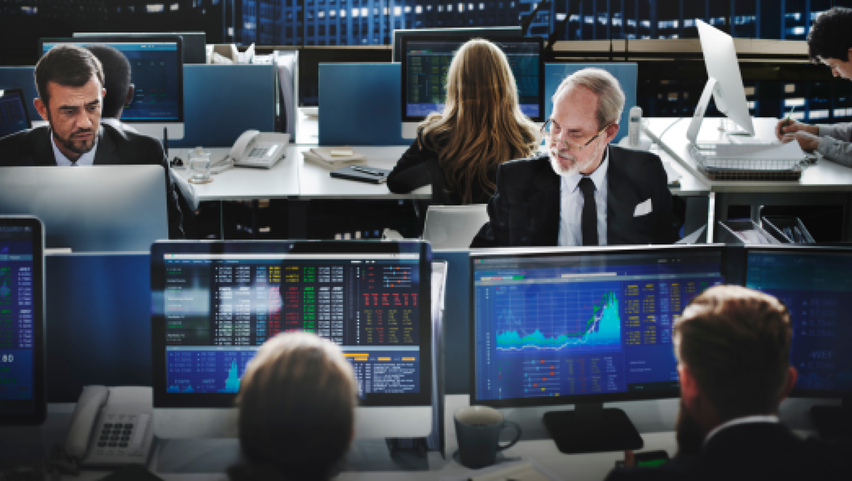 Broker sitting in front of their computers at the stock market